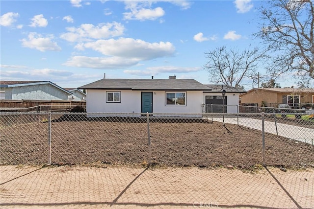 ranch-style house featuring a fenced front yard and driveway