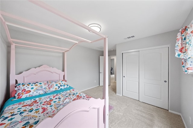 bedroom with baseboards, visible vents, light carpet, and a closet