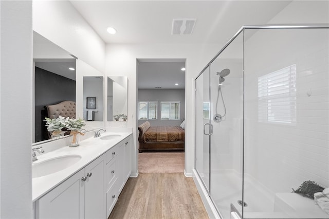 ensuite bathroom featuring a shower stall, connected bathroom, visible vents, and a sink