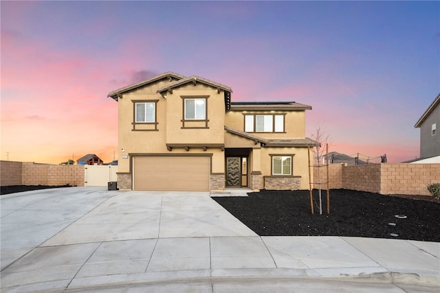 view of front facade featuring stucco siding, roof mounted solar panels, fence, concrete driveway, and a garage