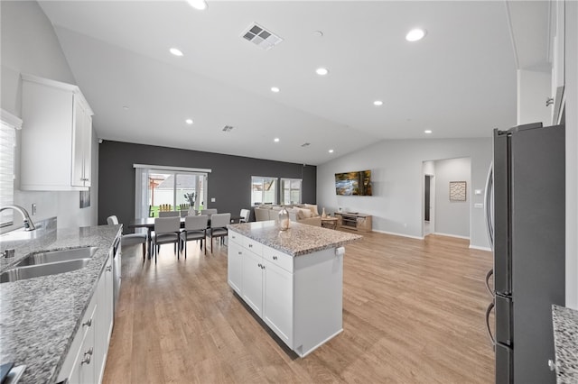 kitchen with a sink, visible vents, light wood-style floors, and freestanding refrigerator