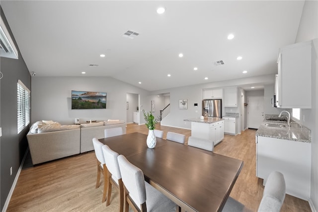 dining area featuring lofted ceiling, recessed lighting, visible vents, and light wood finished floors