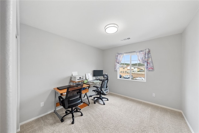 carpeted office with visible vents and baseboards