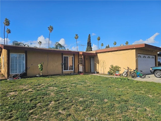 ranch-style house with an attached garage, a front lawn, and stucco siding