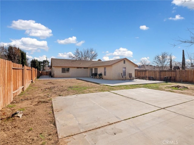 back of house featuring a patio area, a fenced backyard, and stucco siding