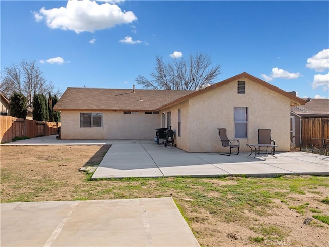 back of house with a patio area, fence, and stucco siding