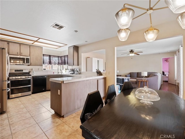 kitchen featuring light tile patterned floors, visible vents, appliances with stainless steel finishes, open floor plan, and a peninsula