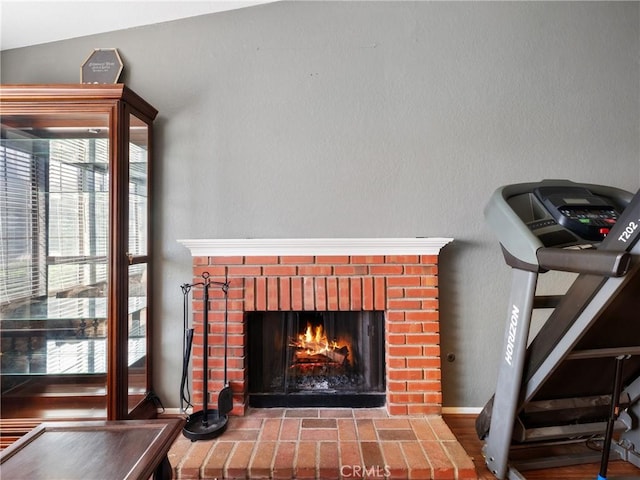 room details featuring a fireplace, wood finished floors, and baseboards