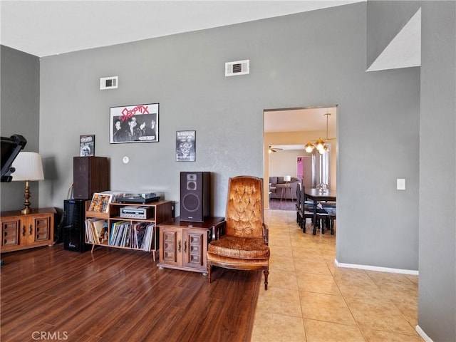 sitting room with wood finished floors, visible vents, and baseboards