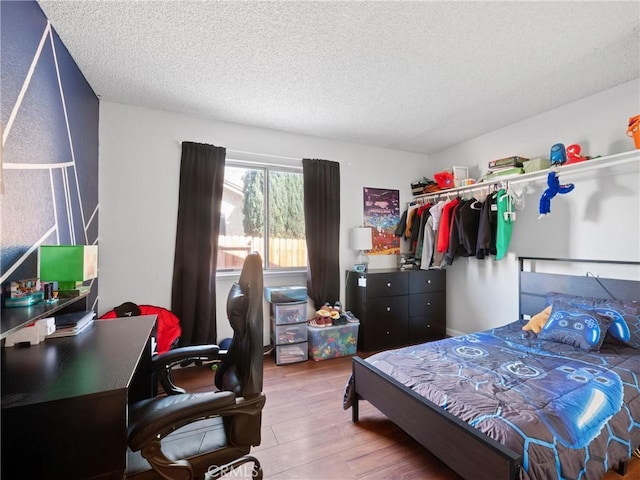 bedroom featuring a textured ceiling and wood finished floors