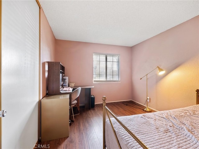 bedroom featuring baseboards and wood finished floors