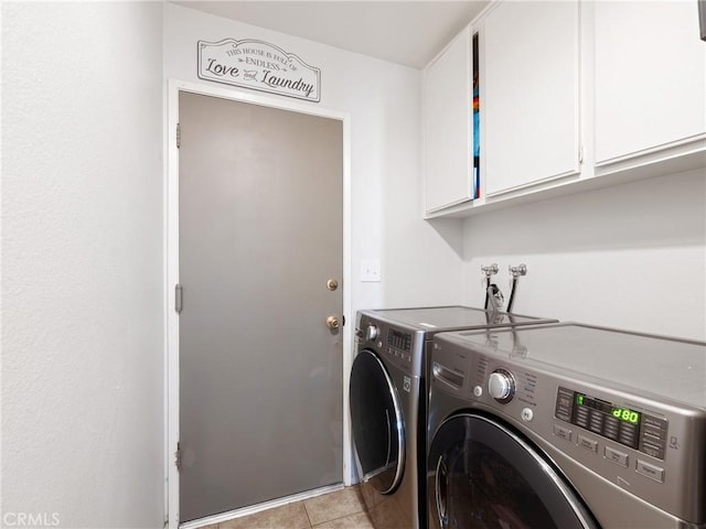 laundry area with cabinet space, separate washer and dryer, and light tile patterned flooring