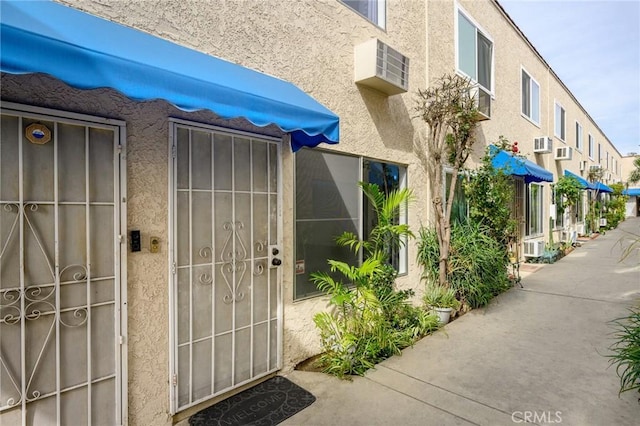 view of exterior entry featuring stucco siding