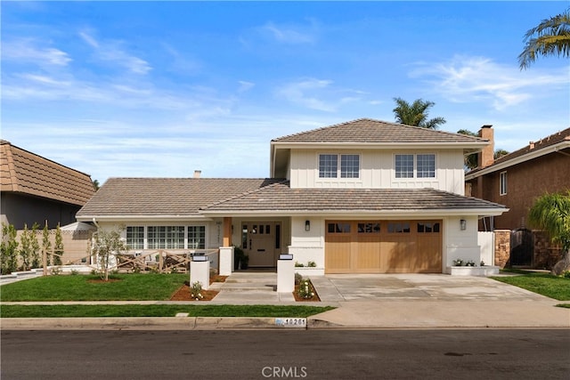 view of front facade featuring driveway, a garage, and a tiled roof