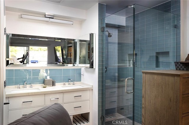 full bathroom with double vanity, a stall shower, a sink, and decorative backsplash