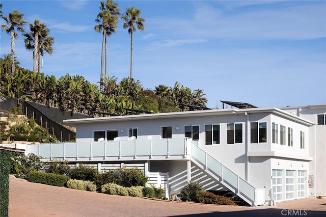 exterior space with stairway and stucco siding