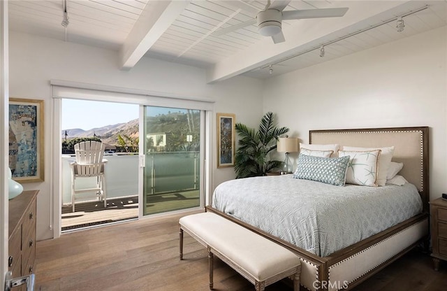 bedroom with access to exterior, beam ceiling, a mountain view, ceiling fan, and wood finished floors