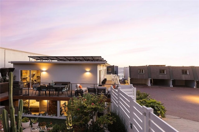 rear view of house with fence and stucco siding