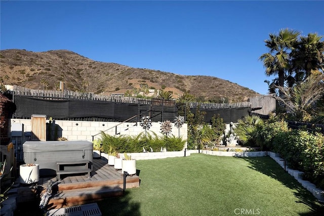 view of yard featuring a mountain view, a hot tub, and fence