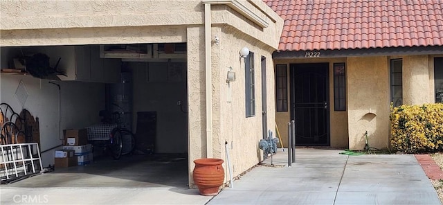 doorway to property featuring a tile roof and stucco siding