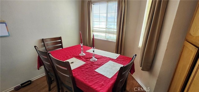 dining space featuring baseboards and wood finished floors