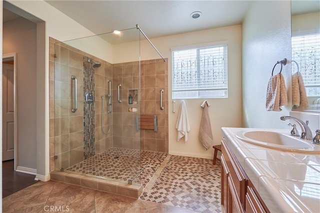 bathroom with baseboards, a shower stall, vanity, and tile patterned floors