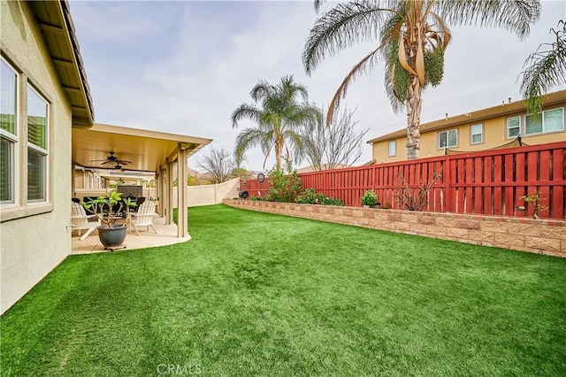 view of yard featuring a patio area, a fenced backyard, and a ceiling fan