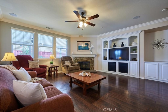 living area with a stone fireplace, visible vents, dark wood-style flooring, and ornamental molding