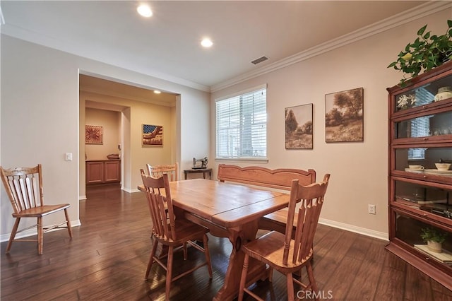 dining area with baseboards, visible vents, dark wood finished floors, and ornamental molding