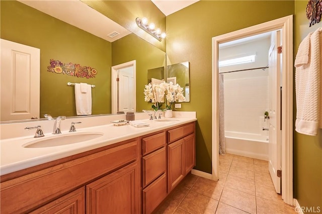 full bathroom featuring double vanity, a sink, visible vents, and tile patterned floors