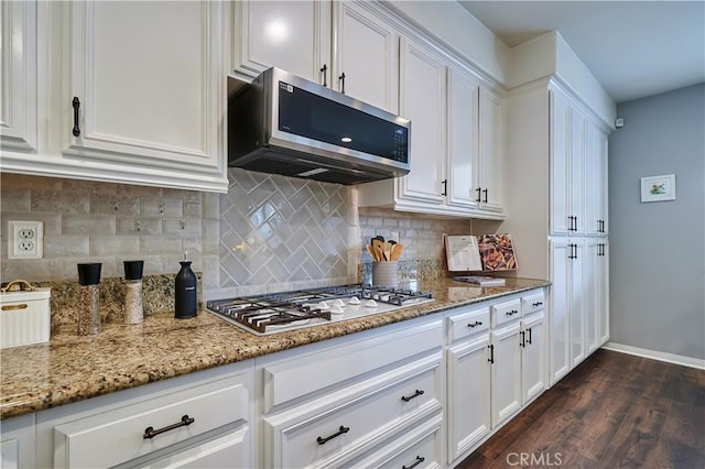 kitchen featuring white gas cooktop, light stone countertops, stainless steel microwave, and white cabinetry