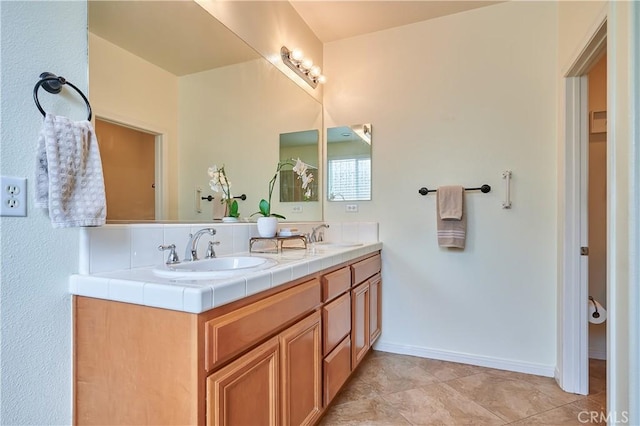 full bath with a sink, baseboards, and double vanity