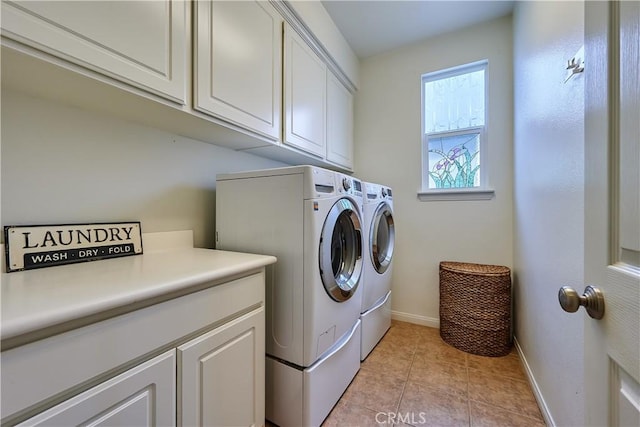 clothes washing area featuring cabinet space, light tile patterned floors, baseboards, and washer and clothes dryer