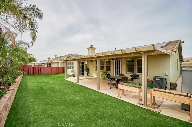 rear view of property with a patio, central AC unit, fence, a lawn, and stucco siding