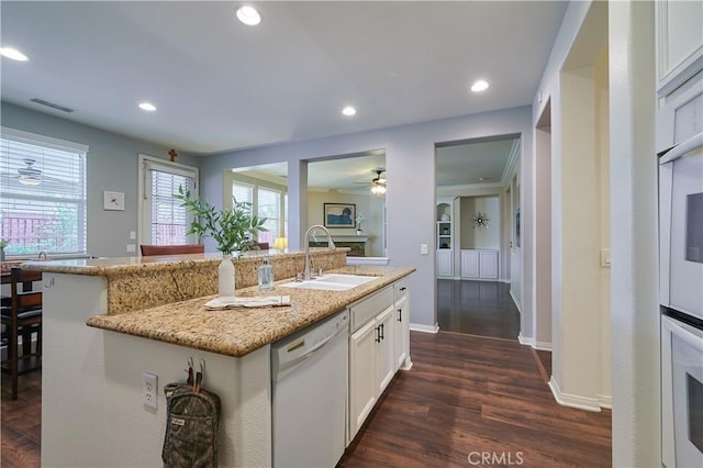 kitchen featuring recessed lighting, white appliances, dark wood-type flooring, a sink, and visible vents