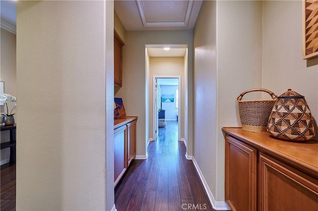 hallway featuring dark wood-style flooring and baseboards