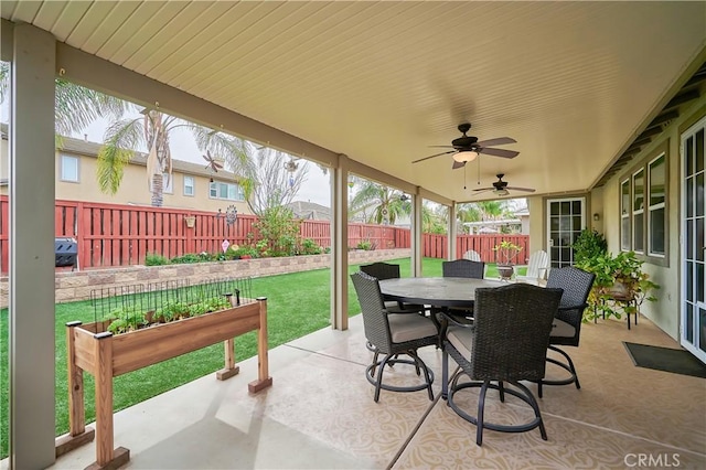 view of patio with outdoor dining area, ceiling fan, and fence