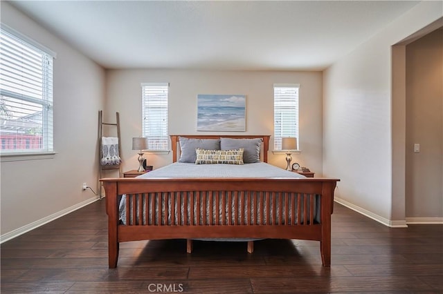 bedroom featuring multiple windows, baseboards, and wood finished floors