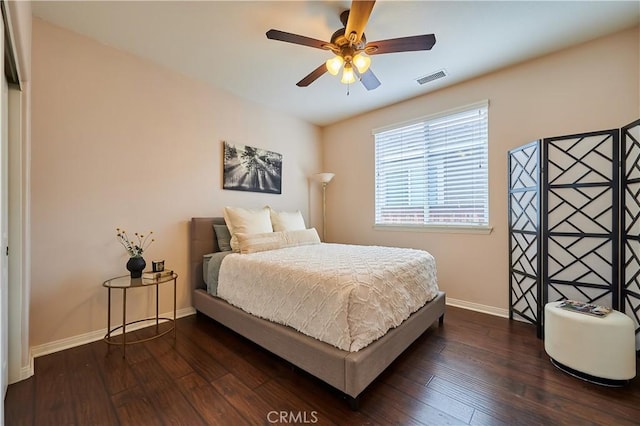 bedroom featuring a ceiling fan, dark wood finished floors, visible vents, and baseboards