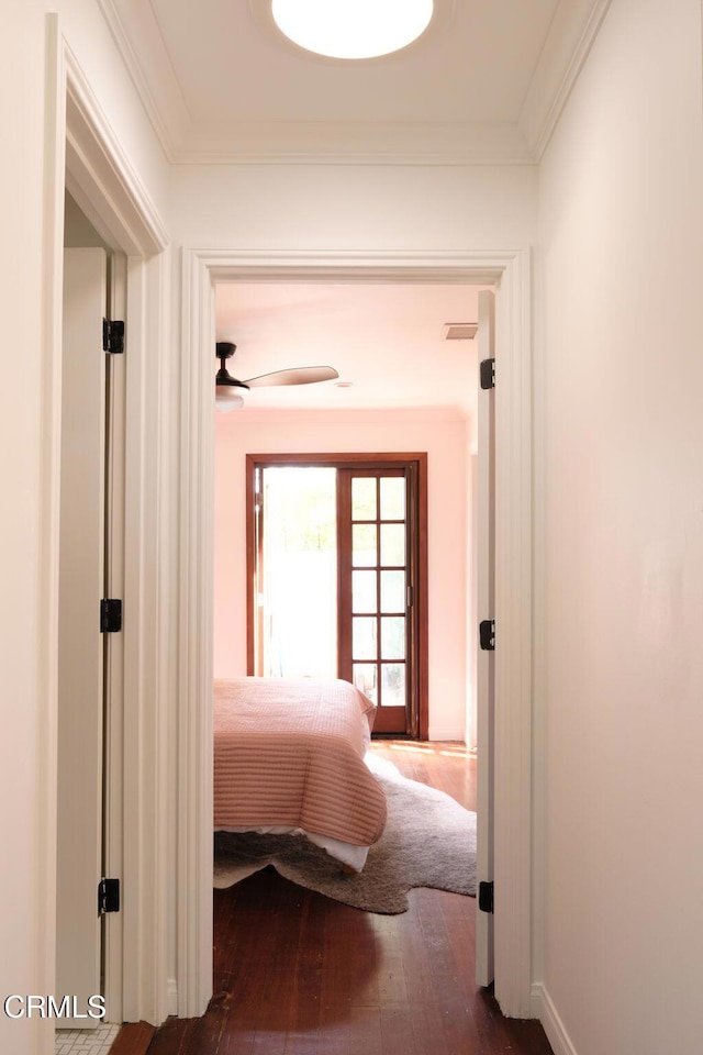 hall featuring wood-type flooring and crown molding