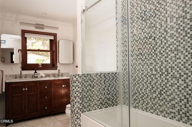 full bathroom featuring double vanity, a sink, toilet, and crown molding