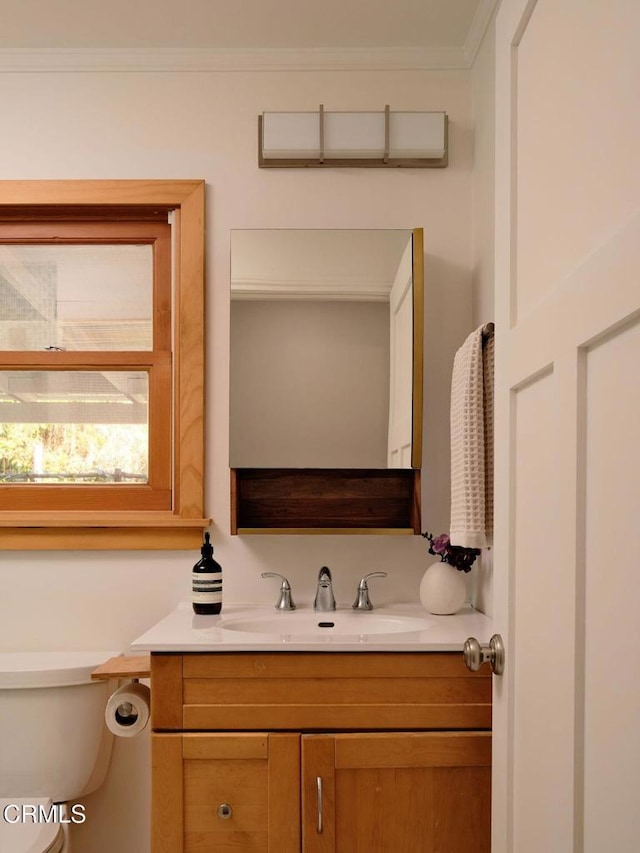 half bath featuring toilet, ornamental molding, and vanity