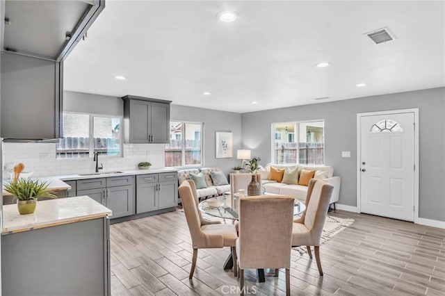 dining room with light wood finished floors, visible vents, and recessed lighting