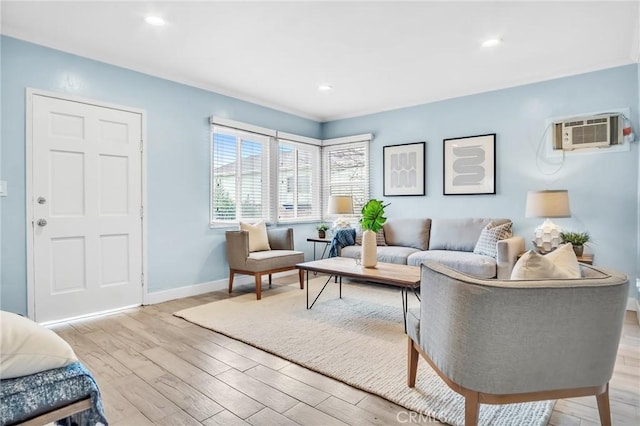 living area featuring recessed lighting, a wall mounted air conditioner, light wood-style flooring, and baseboards