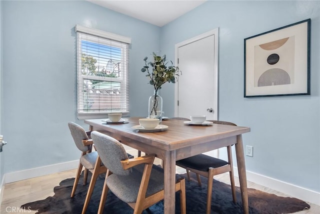 dining space featuring wood finished floors and baseboards