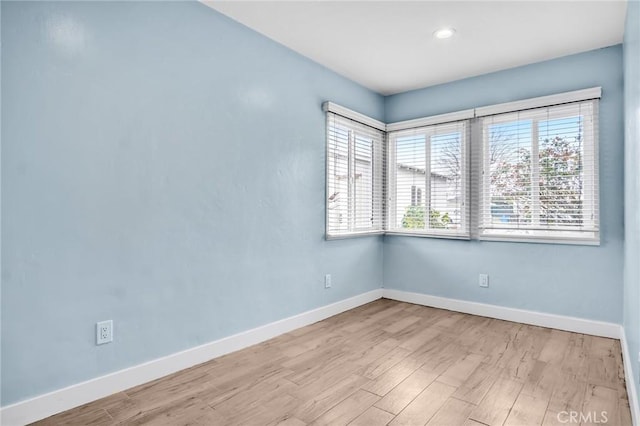 unfurnished room with baseboards, wood finished floors, and recessed lighting