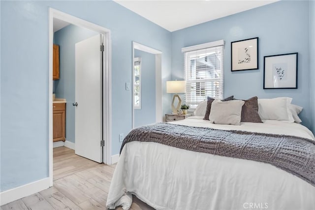 bedroom with light wood-type flooring and baseboards