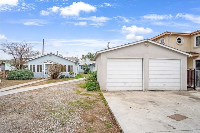 view of front of home with an attached garage, concrete driveway, and stucco siding