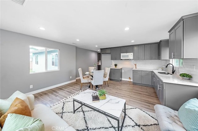 living area with light wood-type flooring, baseboards, and recessed lighting