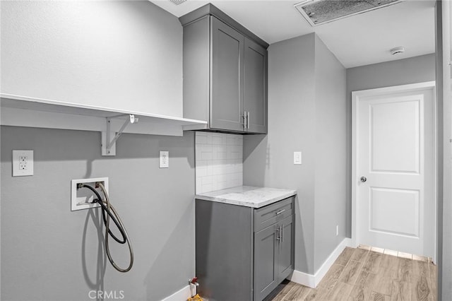 laundry room with light wood finished floors, cabinet space, baseboards, visible vents, and hookup for a washing machine